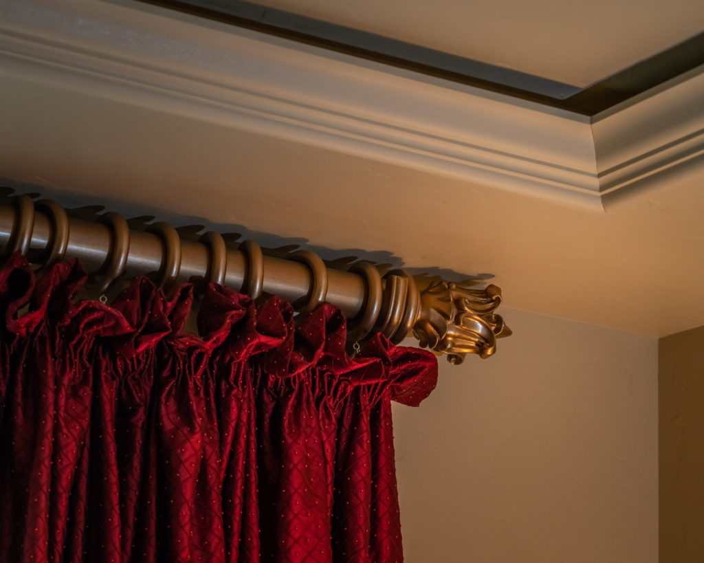 close up of ruffled heading on red silk drapery on gold wood rod